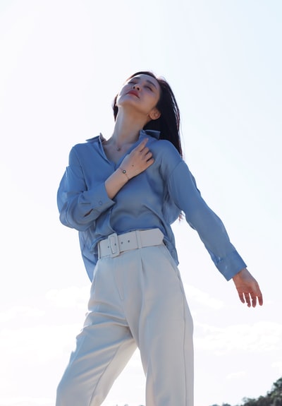 Women wearing the blue long sleeve shirt and white pants
